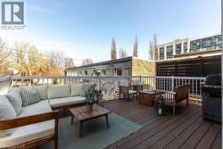 Spacious outdoor deck featuring composite decking, white railing, privacy screen, and exterior lighting - 