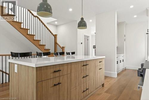 Kitchen island featuring a light wood-finish base, white countertop, and dark hardware - 128 Canada Street, Hamilton, ON - Indoor Photo Showing Other Room