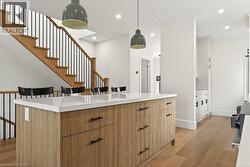Kitchen island featuring a light wood-finish base, white countertop, and dark hardware - 