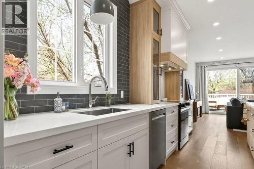 Bright kitchen featuring white shaker cabinetry, stainless steel sink, and light countertops - 128 Canada Street, Hamilton, ON - Indoor Photo Showing Kitchen With Upgraded Kitchen