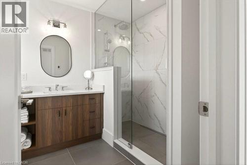 Bathroom featuring a glass-enclosed shower with white marble-style tiled walls and a rain showerhead - 128 Canada Street, Hamilton, ON - Indoor Photo Showing Bathroom