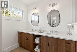 Dual vanity featuring wood-finish cabinetry and white countertops - 