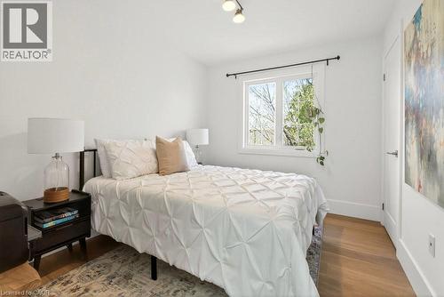 Bright room featuring light wood-finish flooring, white walls, and a white-trimmed window - 128 Canada Street, Hamilton, ON - Indoor Photo Showing Bedroom