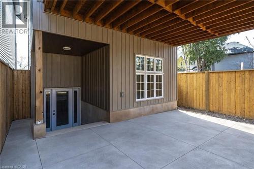 Covered concrete patio space featuring exposed wood joists and a privacy fence - 128 Canada Street, Hamilton, ON - Outdoor With Deck Patio Veranda With Exterior