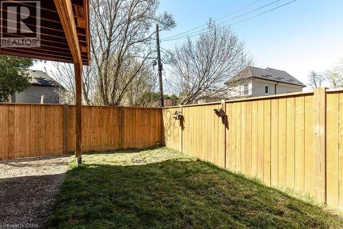 Fenced backyard featuring a gravel patio area and a grass lawn - 128 Canada Street, Hamilton, ON - Outdoor