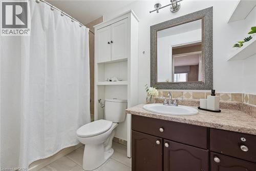 Bathroom featuring a shower with tile surround, toilet, and vanity with an integrated sink - 365 Pioneer Drive Unit# 25, Kitchener, ON - Indoor Photo Showing Bathroom