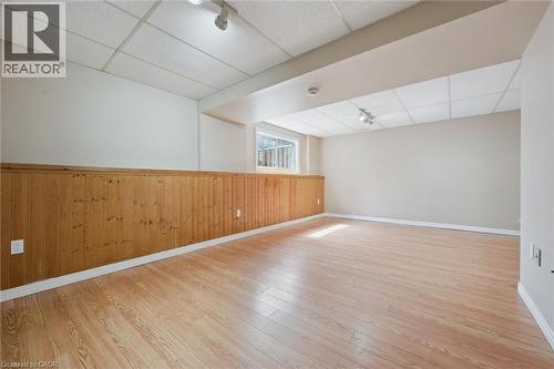 Spacious room featuring wood-finish flooring, half-wall wood paneling, and a drop ceiling with recessed lighting - 365 Pioneer Drive Unit# 25, Kitchener, ON - Indoor Photo Showing Other Room