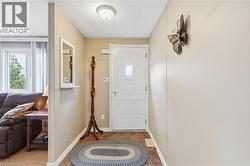 Entryway featuring a white paneled door with glass insert, recessed ceiling light, and wood-finish flooring - 