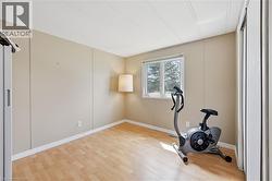 Bright room featuring wood-finish flooring and a single window with exterior scenery - 