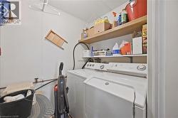 Laundry area featuring white panel walls, wood-finish shelving, and a built-in shelf above the appliances - 