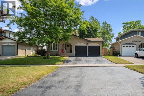 Brick exterior with a prominent mature tree and a two-car attached garage - 97 Bechtel Drive, Kitchener, ON - Outdoor With Facade