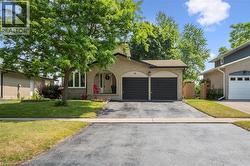 Brick exterior featuring a two-car garage with black doors, an arched entryway, and a bay window - 