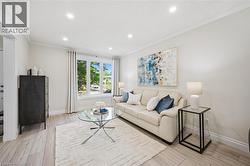 Light wood-finish flooring complements the crown molding and baseboards - 