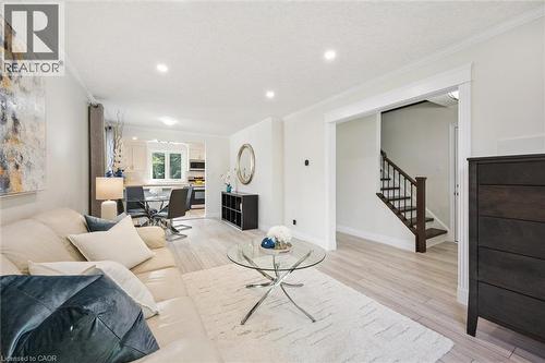Spacious living area featuring light wood-finish flooring, recessed lighting, crown molding, and a white color palette - 97 Bechtel Drive, Kitchener, ON - Indoor Photo Showing Living Room