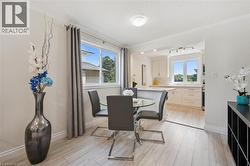 Dining area featuring wood-finish flooring, a large window with natural light, and crown molding - 