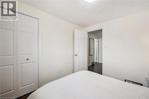 Bedroom featuring light-toned walls, bi-fold closet doors, and dark wood-finish flooring - 97 Bechtel Drive, Kitchener, ON - Indoor Photo Showing Bedroom