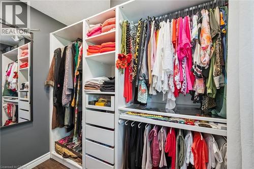 Custom closet system featuring white built-in shelving, multiple hanging rods, integrated drawers, and open storage compartments - 97 Bechtel Drive, Kitchener, ON - Indoor With Storage