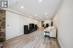 Spacious room featuring wood-finish flooring, recessed lighting, and light-toned walls - 