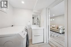 Laundry area featuring a compact vanity with a vessel sink and pull-down faucet, a mirrored medicine cabinet, and recessed ceiling lighting - 