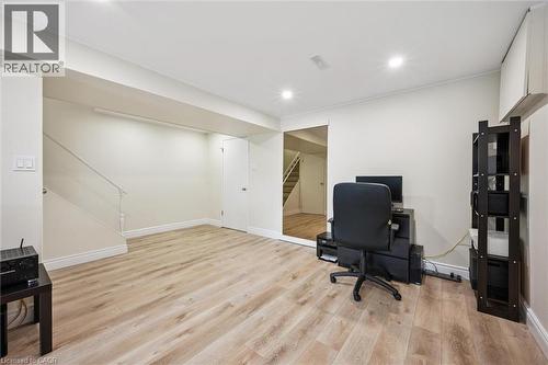 Open concept room featuring wood-finish flooring, recessed lighting, and a white painted staircase with a railing - 97 Bechtel Drive, Kitchener, ON - Indoor