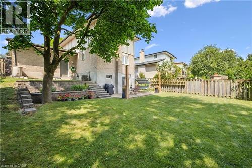 Expansive backyard featuring a large grass lawn, mature trees, and wood fencing - 97 Bechtel Drive, Kitchener, ON - Outdoor
