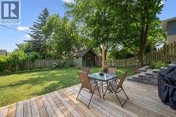 Expansive outdoor space featuring a spacious wood deck, manicured lawn, and mature trees - 