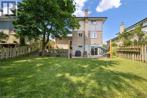 Spacious rear yard with a large grassy area, mature tree, and wood fencing - 97 Bechtel Drive, Kitchener, ON - Outdoor With Exterior