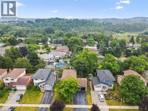 Aerial capture of a residential neighborhood featuring detached homes with varied architectural styles and mature landscaping - 97 Bechtel Drive, Kitchener, ON - Outdoor With View