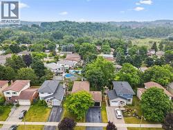 Aerial capture of a residential neighborhood featuring detached homes with varied architectural styles and mature landscaping - 