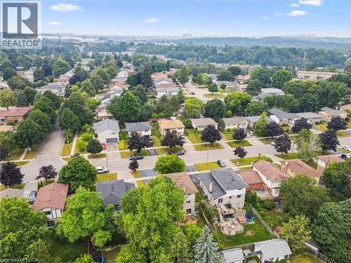 Aerial overview showcasing a residential neighborhood with numerous detached homes, mature trees, and paved streets - 97 Bechtel Drive, Kitchener, ON - Outdoor With View