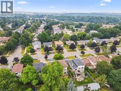 Aerial overview showcasing a residential neighborhood with numerous detached homes, mature trees, and paved streets - 