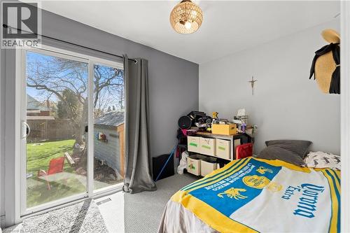 Sliding glass door opening to a private backyard with a storage shed - 25 East 39Th Street, Hamilton, ON - Indoor Photo Showing Bedroom