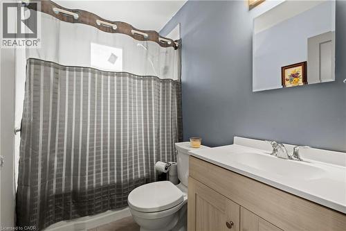 Bathroom featuring a tub/shower combination, light wood-finish vanity with an integrated sink, polished chrome faucet, and a wall-mounted mirror - 25 East 39Th Street, Hamilton, ON - Indoor Photo Showing Bathroom