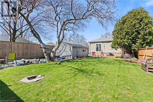 Expansive green lawn with a built-in fire pit, surrounded by a wood privacy fence - 25 East 39Th Street, Hamilton, ON - Outdoor
