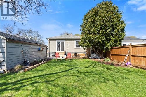 Expansive backyard with manicured lawn, mature tree, and wood privacy fence - 25 East 39Th Street, Hamilton, ON - Outdoor