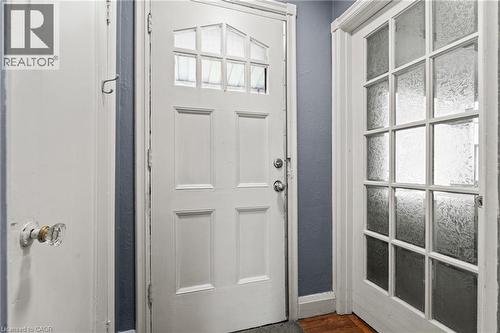 White paneled door with upper glass inserts, accompanied by a multi-paneled door featuring frosted glass - 25 East 39Th Street, Hamilton, ON - Indoor Photo Showing Other Room