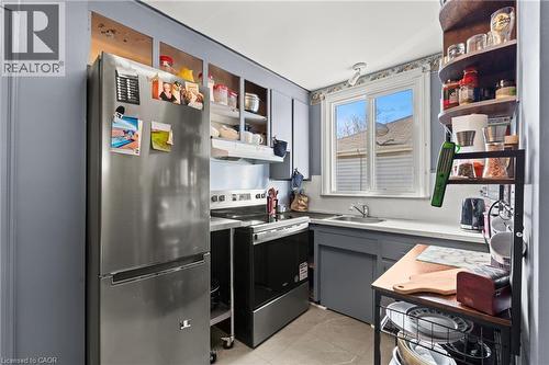 Kitchen featuring a stainless steel refrigerator, white countertops, gray cabinetry, a double-pane window, and tile flooring - 25 East 39Th Street, Hamilton, ON - Indoor Photo Showing Other Room