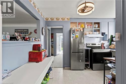 Kitchen featuring a stainless steel refrigerator, electric range, and light gray cabinetry - 25 East 39Th Street, Hamilton, ON - Indoor