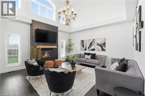 Vaulted ceilings featuring upper transom windows and a traditional chandelier - 47 Winners Way, Binbrook, ON - Indoor Photo Showing Living Room With Fireplace