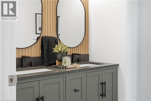 Dual vanity with integrated sinks and dark stone countertops - 47 Winners Way, Binbrook, ON - Indoor Photo Showing Bathroom