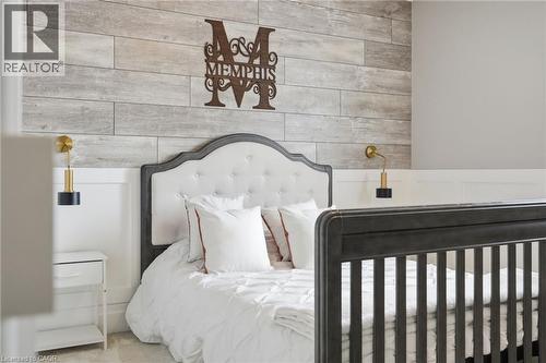 Accent wall featuring horizontal wood-finish paneling above a white wainscoting - 47 Winners Way, Binbrook, ON - Indoor Photo Showing Bedroom