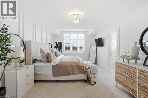 Bright interior space featuring a window with plantation shutters, recessed ceiling lighting, a decorative ceiling fixture, and a white paneled accent wall - 47 Winners Way, Binbrook, ON - Indoor Photo Showing Bedroom