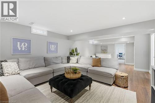 Finished lower level with recessed lighting, wood-finish flooring, and light gray wall tones - 47 Winners Way, Binbrook, ON - Indoor Photo Showing Living Room