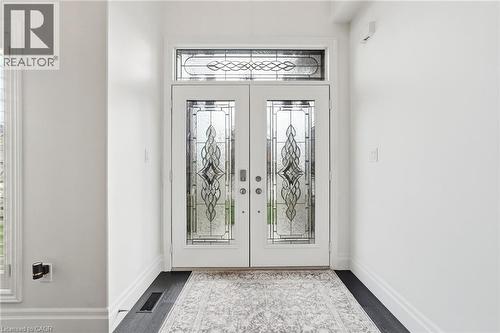 Double entry doors with decorative glass panels and an arched transom window - 47 Winners Way, Binbrook, ON - Indoor Photo Showing Other Room