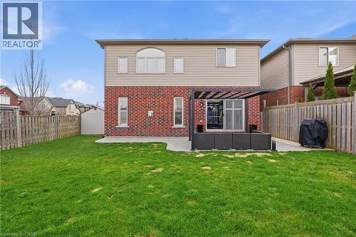 Expansive backyard featuring a lush green lawn, brick and siding exterior, a concrete patio, and a privacy fence - 47 Winners Way, Binbrook, ON - Outdoor With Exterior
