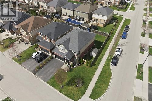 Suburban residential property featuring a gray shingle roof, light-colored siding, and brick accents - 47 Winners Way, Binbrook, ON - 