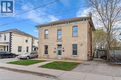 Two-story brick exterior featuring arched window details, a decorative cornice, and a paved driveway - 