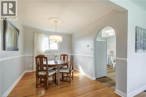 Hardwood flooring, chair rail molding, and a drum pendant light fixture with a ceiling medallion - 217 Lawnhurst Court, Hamilton, ON - Indoor Photo Showing Dining Room