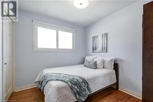 Room featuring wood-finish flooring, light blue wall paint, and white baseboards - 217 Lawnhurst Court, Hamilton, ON - Indoor Photo Showing Bedroom