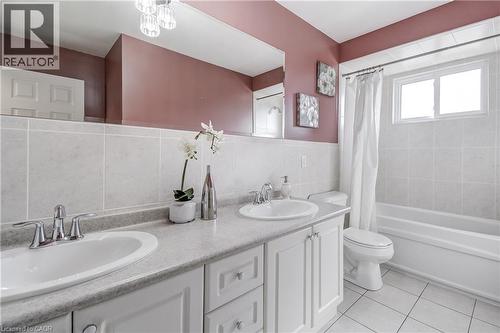 Bathroom featuring a double vanity with white cabinetry, integrated sinks, and chrome fixtures - 217 Lawnhurst Court, Hamilton, ON - Indoor Photo Showing Bathroom